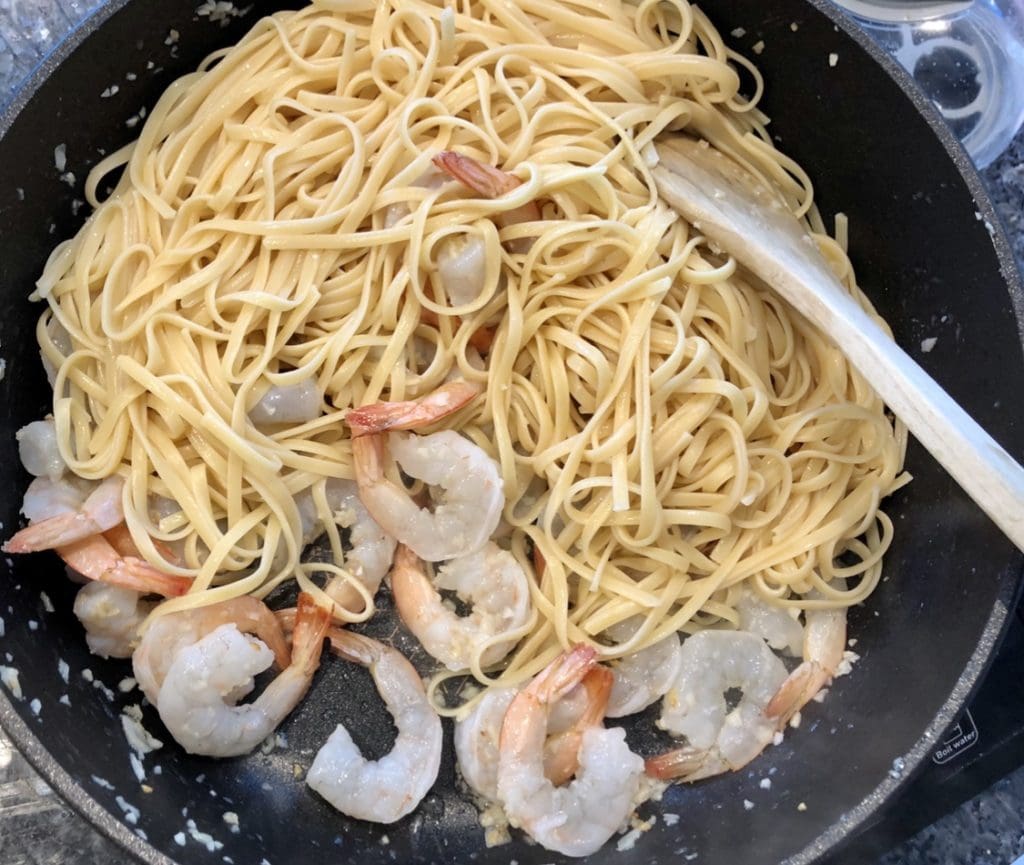 adding the shrimps into the pasta