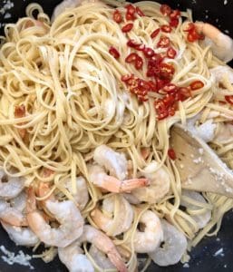 adding chilli into the prawn pasta