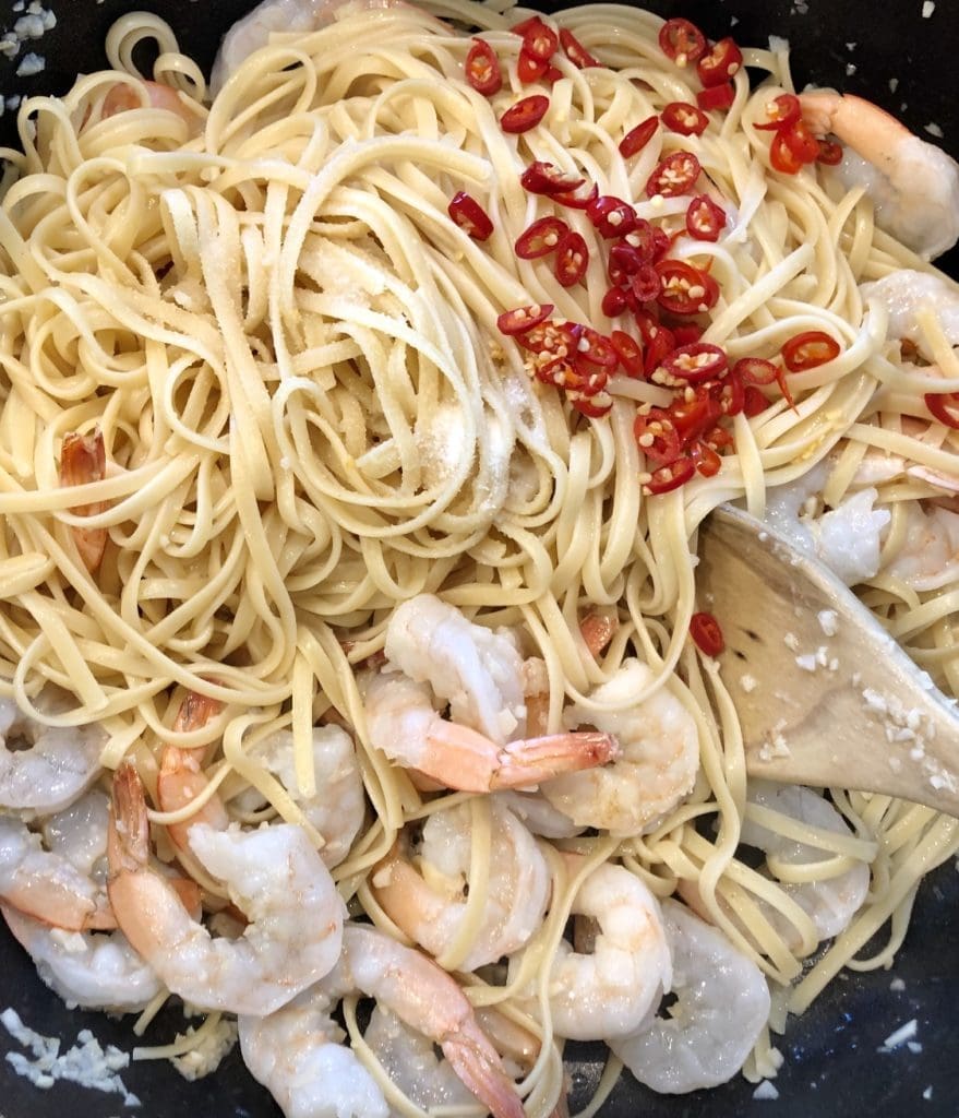 adding chilli into the prawn pasta