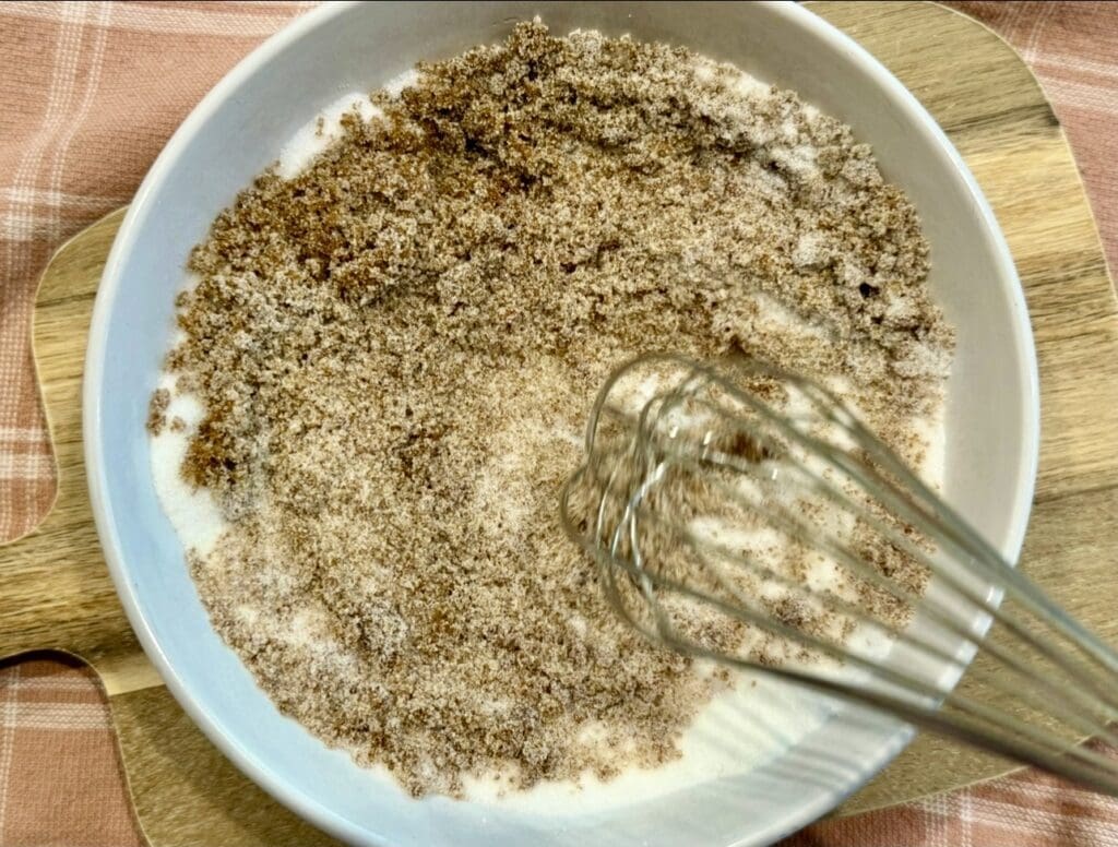 Mixing dark brown sugar and caster sugar in a bowl using a whisk