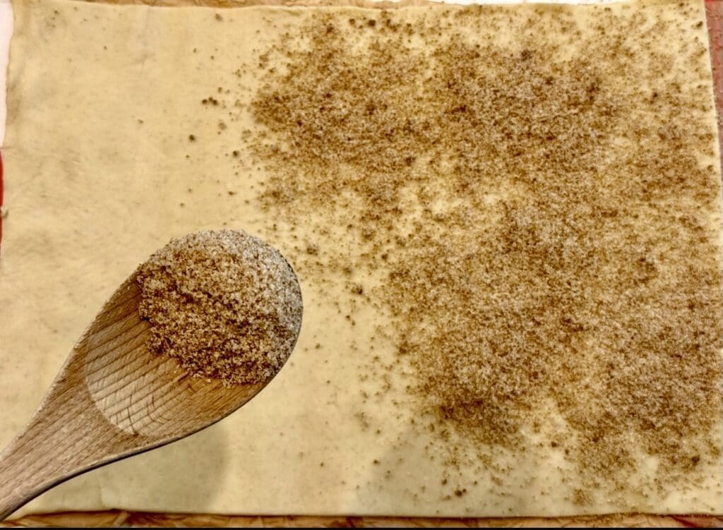 Sprinkling the sugar over the puff pastry sheet